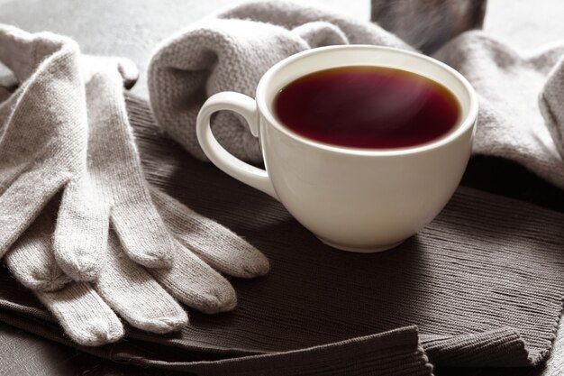 Grey cozy knitted sweater with to cup of coffee on a wooden black table