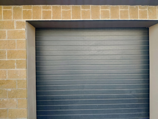 A grey garage door with a black door frame and a white sign that says'the door is closed '