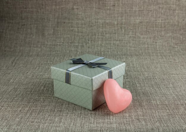 Grey gift box with a heart on a grey background