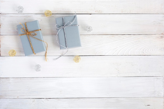 Grey giftboxes on the white wooden background, top view, copy space