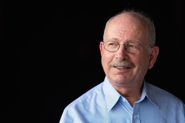 Grey haired senior man with mustache smiling and thinking