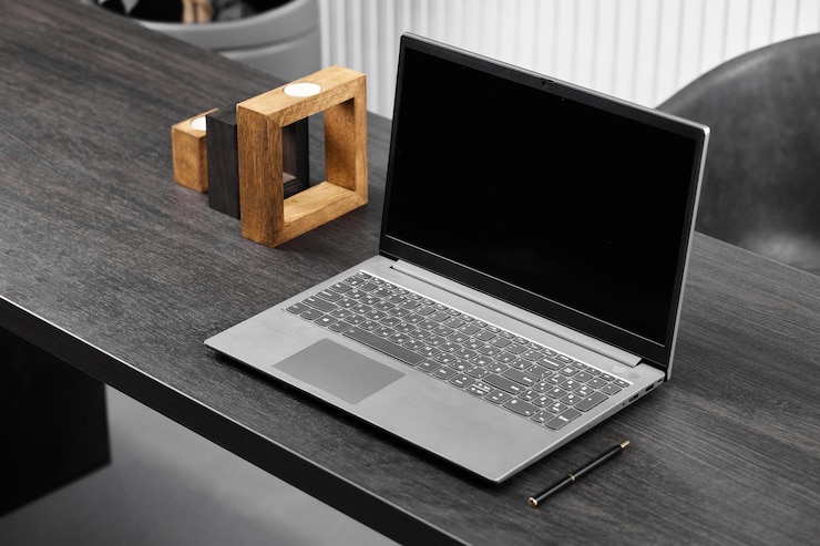 Photo grey laptop on grey background with pen