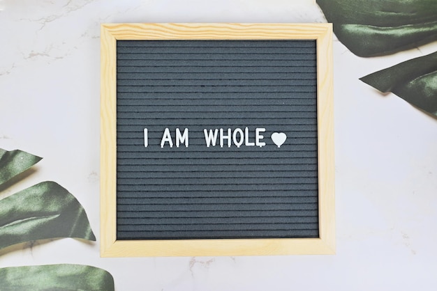 Photo grey letter board with phrase i am whole self love self care on natural background mindfulness lifestyle mental health aspiration and supportive sentence