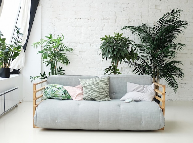 Grey sofa in the room next to the flowers