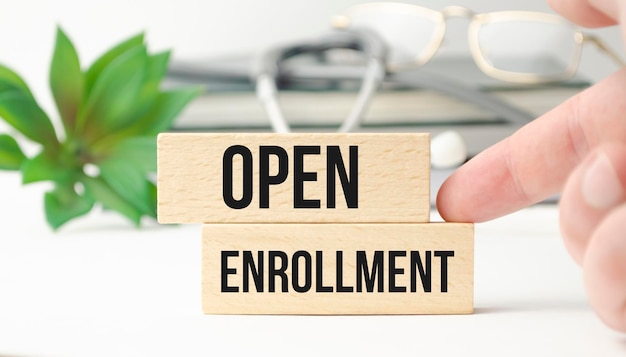 OPEN ENROLLMENT 밝은 파란색 배경 의료 개념이 있는 흰색 종이가 있는 회색 청진기 및 종이 접시