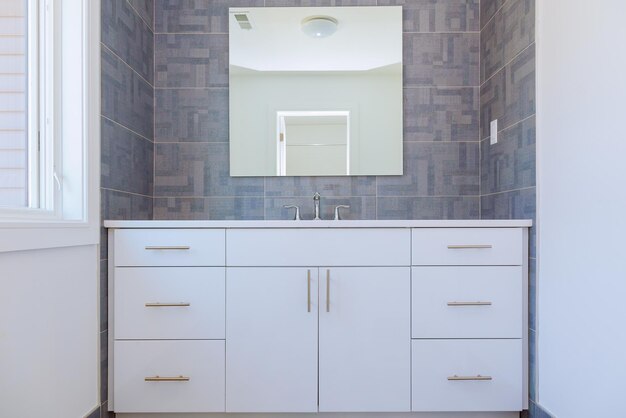 Foto design d'interni per bagno contemporaneo piastrellato con motivo in pietra grigia con mobili minimi in legno naturale