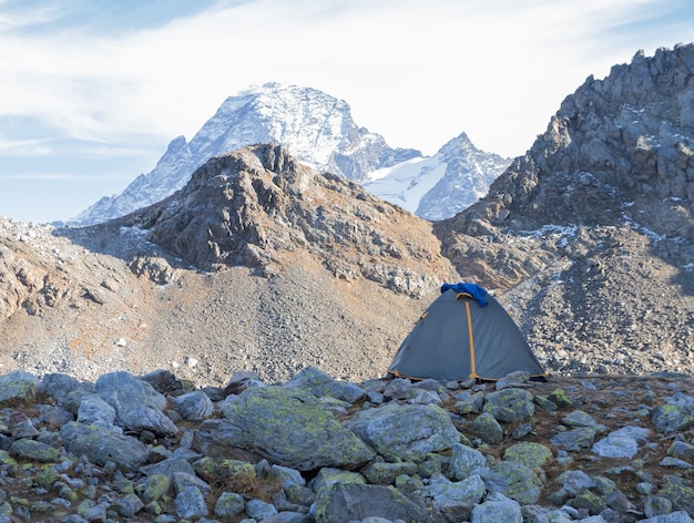 Grey tent on the background of high mountain landscape