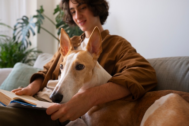 Greyhound hond met mannelijke eigenaar thuis op de bank