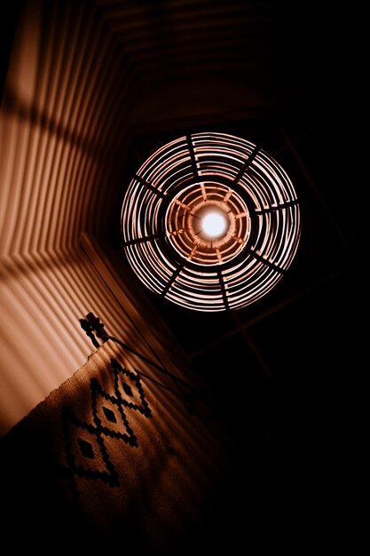 Grid lamp hanging from the ceiling and view from below with reflections on the wall