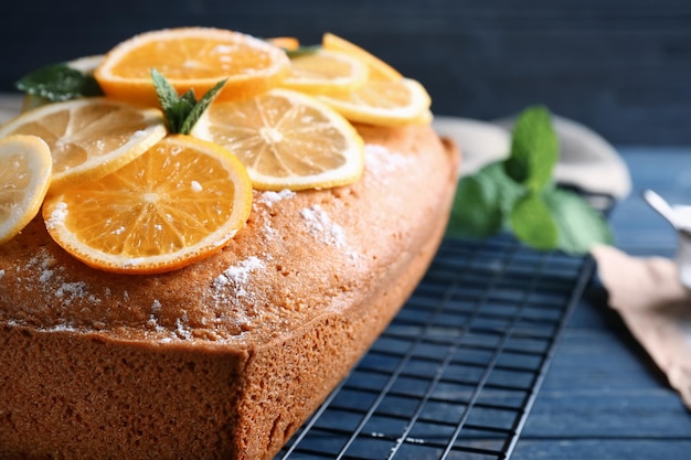 Сетка с вкусным цитрусовым тортом на столе крупным планом