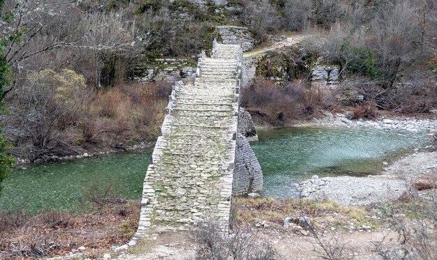 Foto griekenland kalogeriko of plakidas stenen brug zagoria epirus uitzicht vanaf voetgangersbrug rotsachtig pad