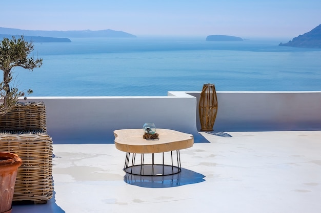 Griekenland. Zonnige zomerdag in Santorini. Tafel op een stenen terras met uitzicht op zee