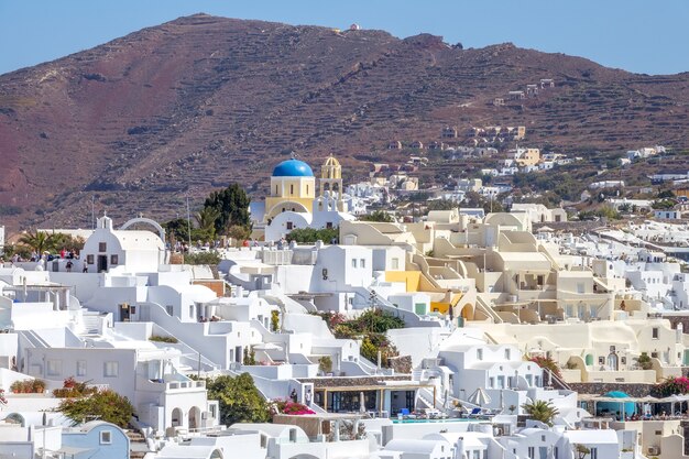 Griekenland. Zonnige zomerdag op het eiland Santorini. Witte gebouwen en de berg op de achtergrond