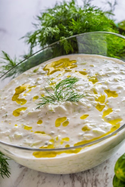 Griekse dip of dressing tzatziki bereid met komkommer zure room yoghurt olijfolie en verse dille