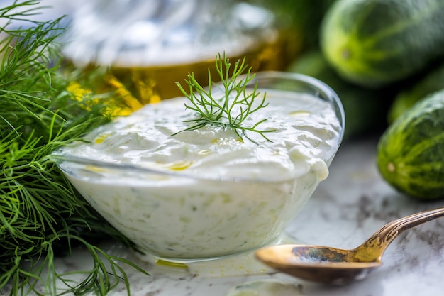 Griekse dip of dressing tzatziki bereid met komkommer zure room yoghurt olijfolie en verse dille