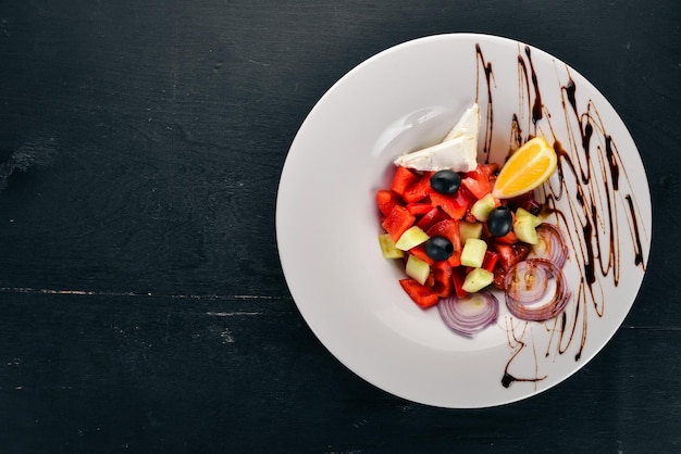 Griekse groentesalade met brie-kaas Op een houten ondergrond Bovenaanzicht Kopieer de ruimte