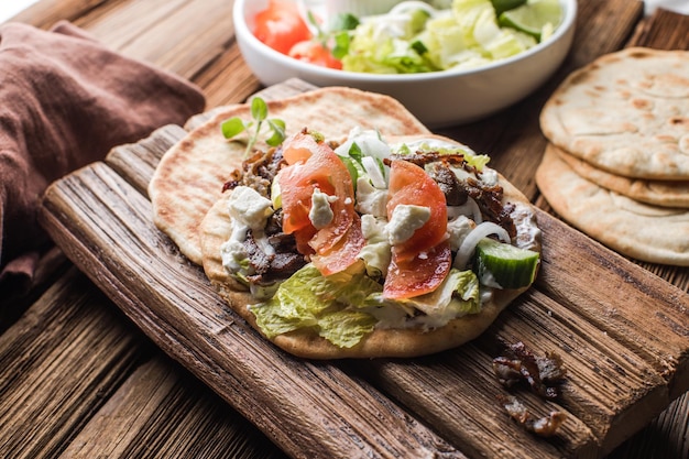 Griekse gyros gewikkeld in pita brood op een houten achtergrond