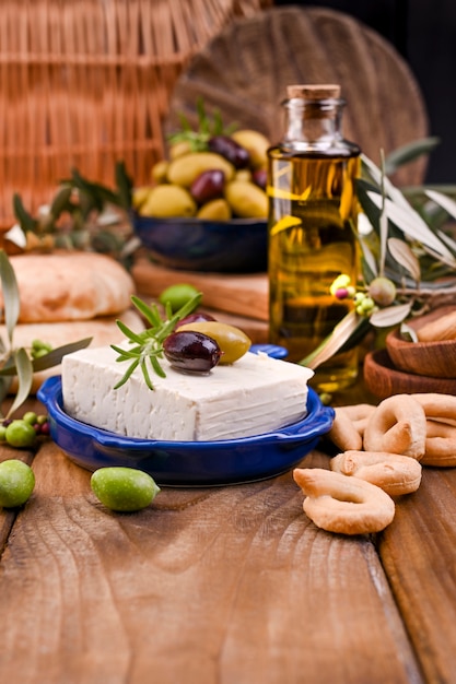 Griekse kaas feta met tijm en olijven. Brood en jonge olijftak