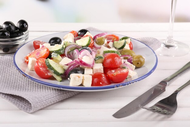 Foto griekse salade geserveerd in plaat op servet op houten tafel op natuurlijke achtergrond