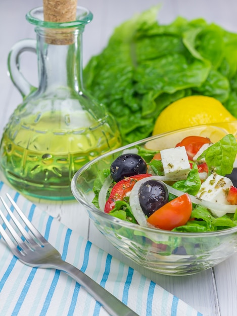 Griekse salade in een glazen kom op houten tafel