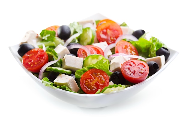 Griekse salade in een kom op wit