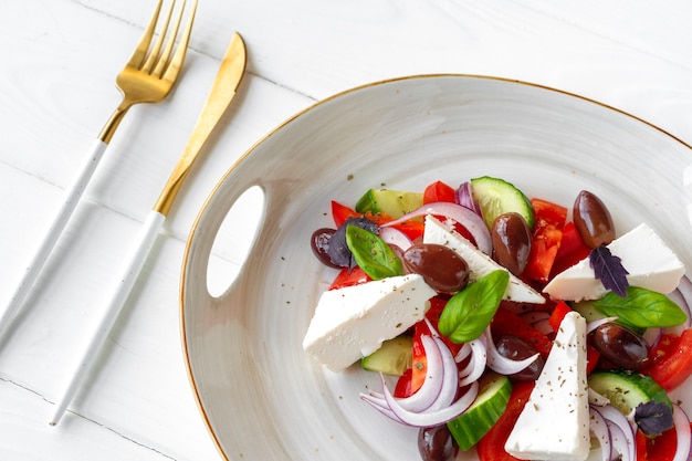 Griekse salade in plaat op wit houten oppervlak