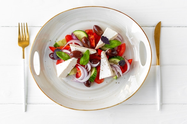 Griekse salade in plaat op witte houten achtergrond