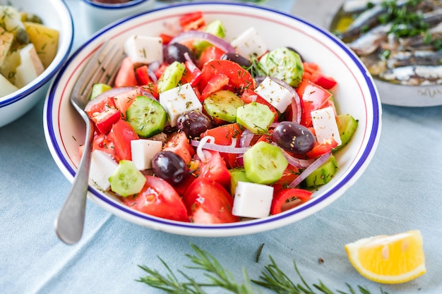 Griekse salade met feta-kaas olijven cherry tomaat paprika komkommer en rode ui gezond vegetarisch mediterraan dieet voedsel lage calorieën eten witte stenen achtergrond bovenaanzicht