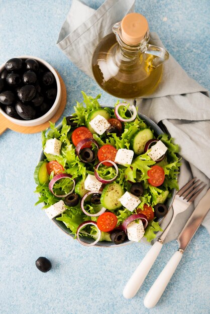 Griekse salade met tomaten, komkommers, olijven en fetakaas in een bord op een betonnen ondergrond, typisch Griekse keuken, bovenaanzicht