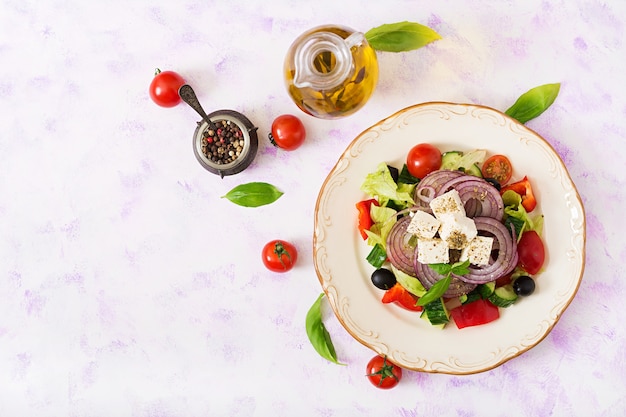 Griekse salade met verse tomaat, komkommer, rode ui, basilicum, sla, fetakaas, zwarte oli