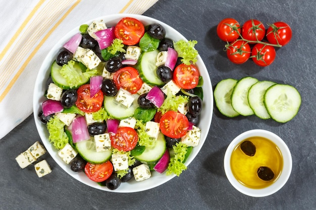 Griekse salade met verse tomaten, olijven en fetakaas gezond eten van bovenaf op een lei