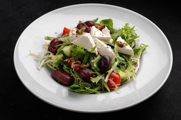 Griekse salade op een bord op een donkere achtergrond