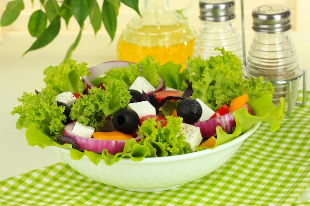 Griekse salade op plaat op tafel op lichte achtergrond