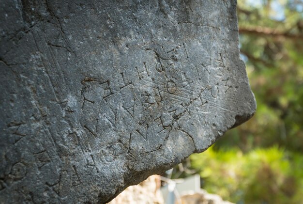Griekse tekst gesneden op oude stenen van Phaselis ruïnes antieke Griekse stad aan de kust van Antalia, Turkije