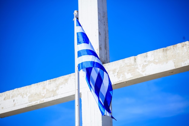 Griekse vlag op een wit kruis en een blauwe hemelachtergrond