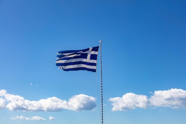 Griekse vlag zwaaien tegen heldere blauwe hemelachtergrond