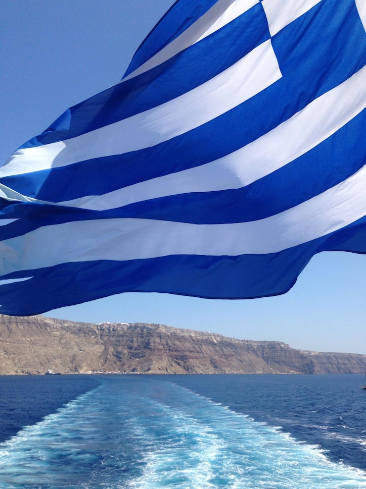 Foto griekse vlag zwaaiend over waak in de zee tegen de lucht