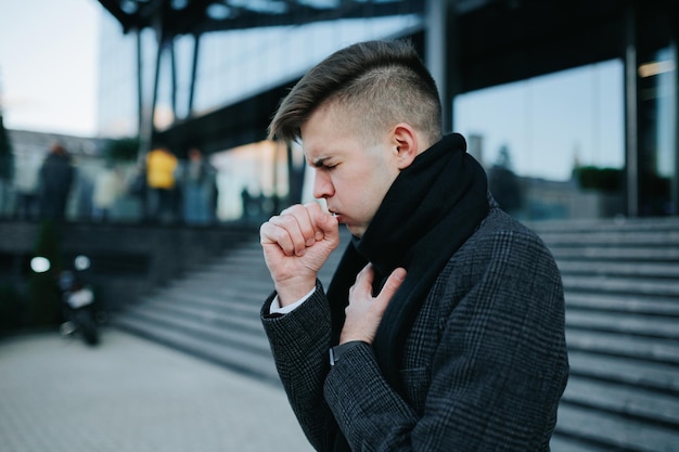 griep ellende een jonge man nies en hoest als gevolg van de griep zichtbaar worstelen met de seizoensgebonden