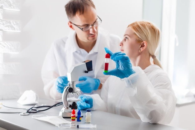 Griepvirusexperiment - wetenschapper in laboratorium met microscoop, draag een veiligheidsbril