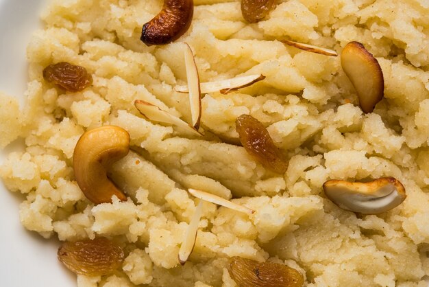 Griesmeel met gewone of saffraansmaak of Soji Halwa, ook bekend als Sweet Rava Sheera OF Shira - Indiaas festivalzoet gegarneerd met droog fruit. Geserveerd in een bord of kom, selectieve focus