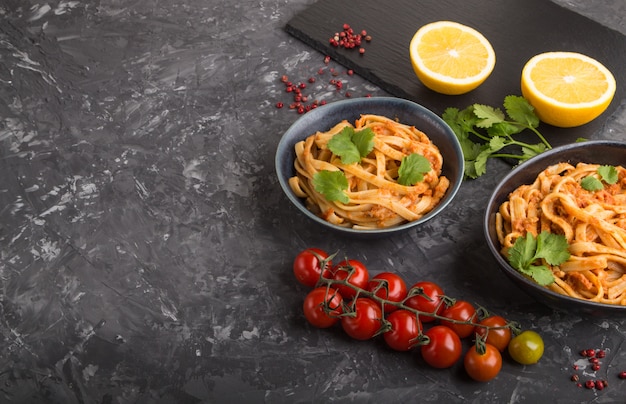 Griesmeelpasta met tomatenpestosaus, sinaasappel en kruiden. Zijaanzicht, copyspace.