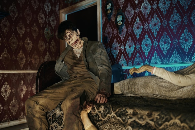 Griezelige enge zombie op bed camera kijken. Halloween-horrorfilm. Post-apocalyptisch concept