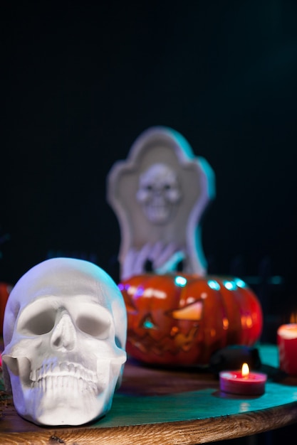 Griezelige menselijke schedel met andere halloween-versieringen op een houten tafel. Halloween-feest.