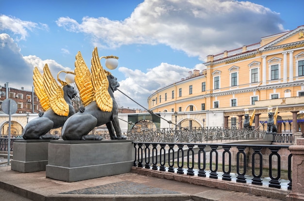 Griffins with golden wings on the Bank Bridge in St. Petersburg and the State Economic University