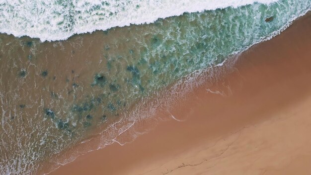 Grijs zeewater bedekt het strand langzaam bewegende stormachtige oceaangolven luchtbeeld van boven