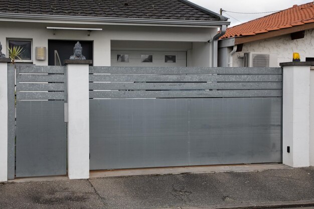 Grijze aluminium rij moderne glijbaan hoge poort naar huis grijs modern paneelportaal van buitenwijk stadshuis