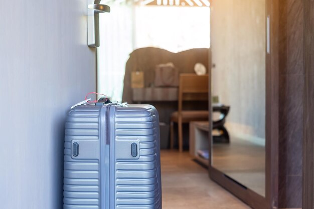 Grijze bagage in moderne hotelkamer na het openen van de deur Tijd om te reizen, reisreis en vakantieconcepten