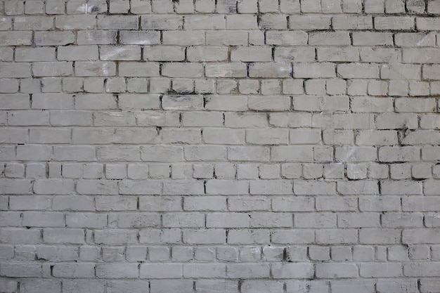 Grijze bakstenen muur Verweerde textuur bevlekte oude verf grijze bakstenen muur Gekleurde bakstenen muur achtergrond
