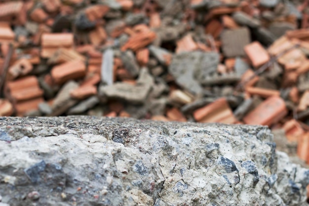 Foto grijze betonnen steen met brocken rode bakstenen op de achtergrond als een ruïne van een bouwdecor