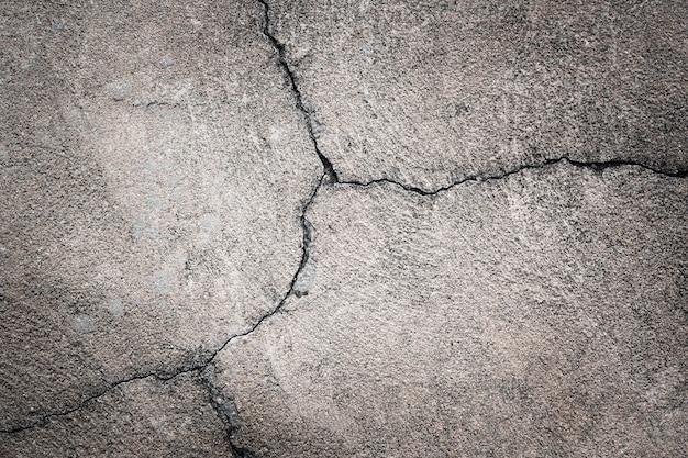 Grijze concrete achtergrond. scheuren in het oude asfalt op de weg